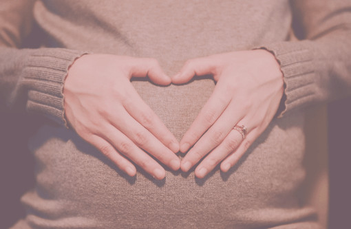 Blogartikel Stoffwindeln für Neugeborene - Schwangere mit Händen zum Herz geformt auf dem Bauch