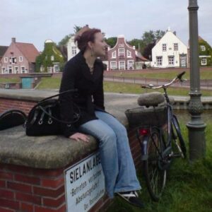 Junge Frau sitzt auf der Mauer einer Sielanlage - Blogartikel Mein Weg zur Stoffwindelberaterin