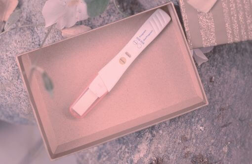 Beitragsbild Blogartikel Anzeichen Schwangerschaft - Schwangerschaftstest im Pappkarton