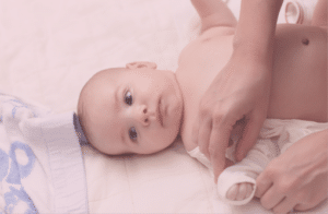 Beitragsbild Blogartikel Die richtige Kleidung für mein Baby - Baby beim Anziehen
