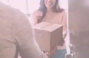 Frau nimmt Paket entgegen und lächelt dabei