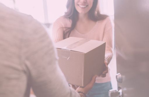 Frau nimmt Paket entgegen und lächelt dabei
