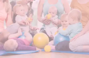 5 Babys sitzen mit ihren Müttern und Bällen im Kreis